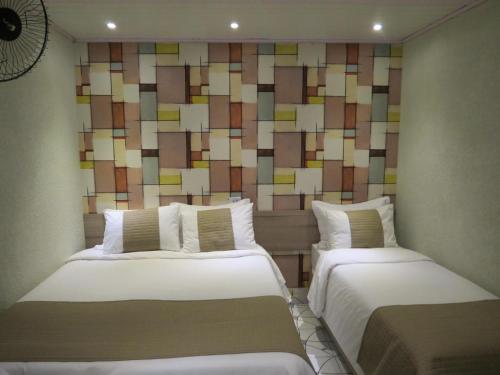 two beds in a room with a colorful wall at Hotel Contorno Sul in Curitiba