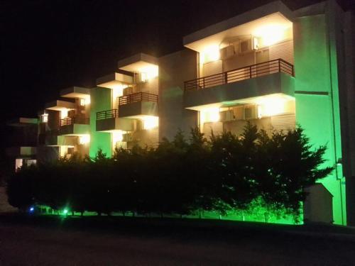 a large apartment building with green and white lights at Maya Bay in Kallithea Halkidikis