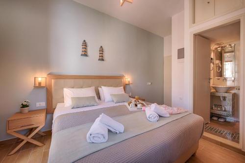 a bedroom with a large bed with towels on it at Kokona in Symi