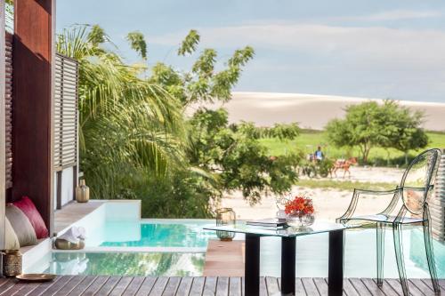a patio with a glass table and chairs on a deck at Essenza Dune Hotel in Jericoacoara
