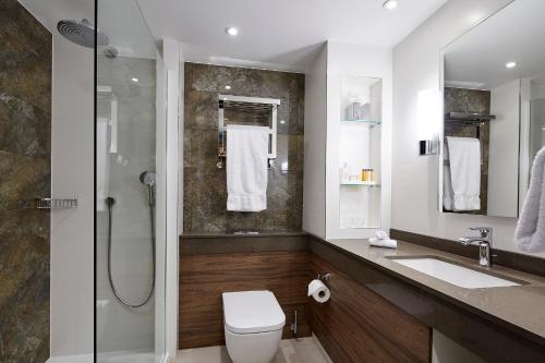 a bathroom with a shower and a toilet and a sink at Sir Christopher Wren Hotel in Windsor
