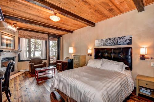 a bedroom with a large bed and a fireplace at Les Condos Du Lac Taureau- Rooms & Condos in Saint-Michel-des-Saints