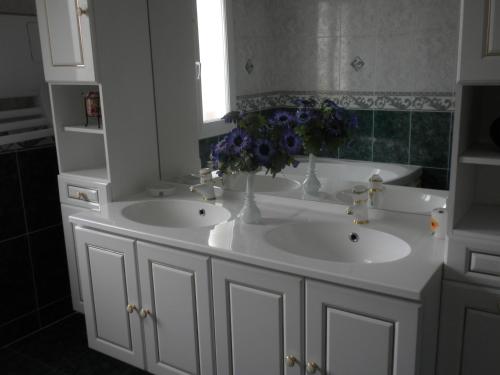 a bathroom with two sinks and a vase of flowers at L'Escapade in Vertus