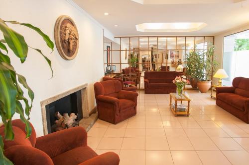 a living room with couches and a fireplace at Hotel Carollo in Mendoza