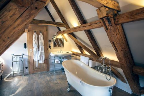 ein Badezimmer mit einer großen Badewanne und einem Waschbecken in der Unterkunft Le B. VINTAGE in Riquewihr
