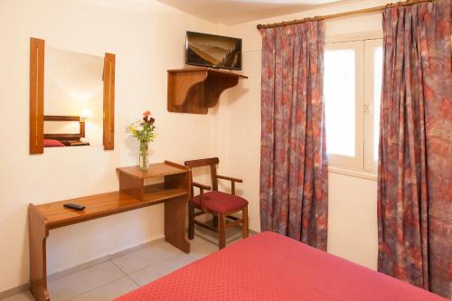 a bedroom with a desk and a chair and a window at Hotel Carollo in Mendoza