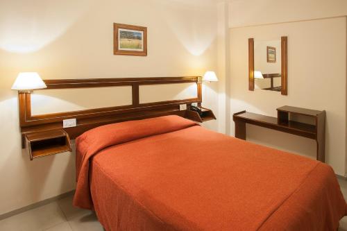 Säng eller sängar i ett rum på Hotel Carollo