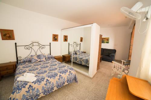 阿爾赫西拉斯的住宿－豪斯皮達耶阿爾赫西拉斯酒店，一间卧室配有一张床和镜子