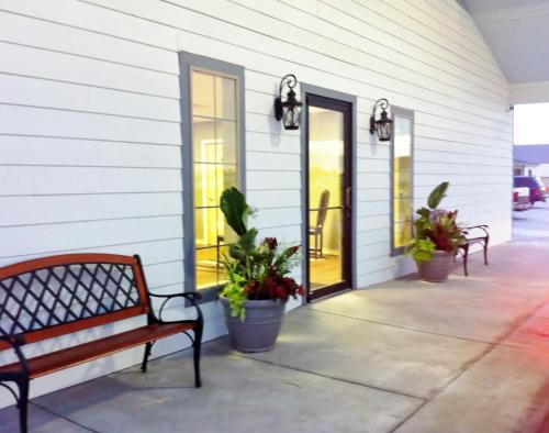 a porch with benches and plants on a building at Southern Inn and Suites Kermit in Kermit