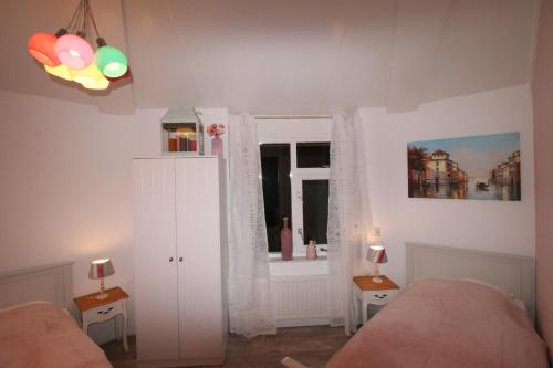 a bedroom with two beds and a window at Ferienhaus am Meer mit Kamin & Sauna - Seestern 251 in Julianadorp