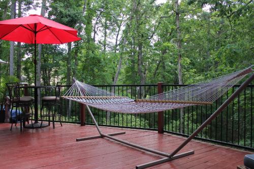 a hammock on a deck with a red umbrella at Brydan Suites in Eureka Springs