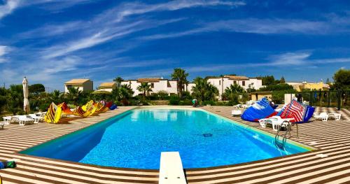 a swimming pool with lounge chairs and a resort at Case Vacanza Torre Lupa in Marsala