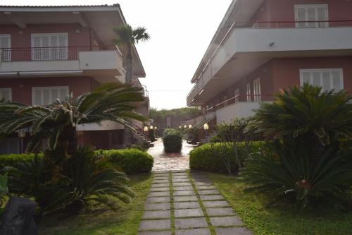 a walkway in front of a building with palm trees at SeaHome in Riposto