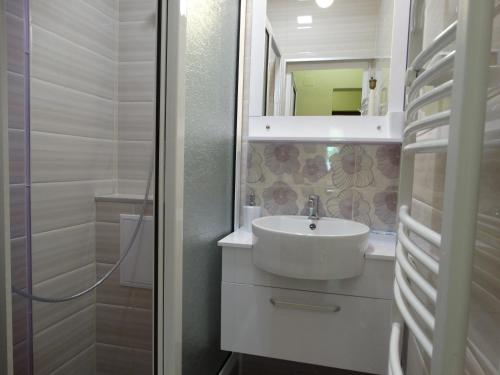 a white bathroom with a sink and a mirror at Old Center Apartment in Ruse