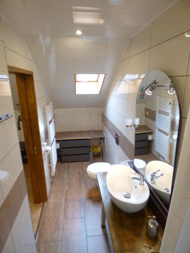 a bathroom with two sinks and a mirror at Appartment am Waldmattensee in Lahr