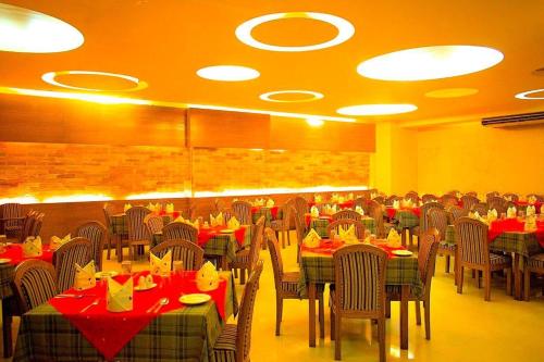 فندق إيجيان أس آر في شيتاغونغ: غرفة طعام مع طاولات وكراسي بمناديل حمراء