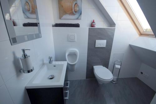 a small bathroom with a toilet and a sink at Pension / Zimmervermietung Wasbek in Wasbek