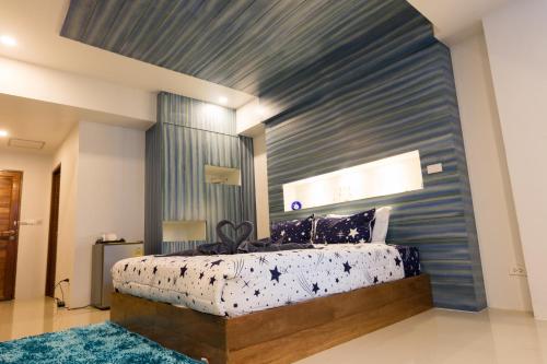 a bedroom with a large bed with a blue wall at 2 Feel Bed Station in Udon Thani