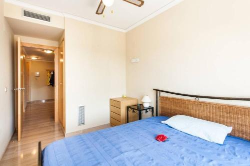ein Schlafzimmer mit einem blauen Bett mit einer roten Blume darauf in der Unterkunft Biopark View Apartment in Valencia