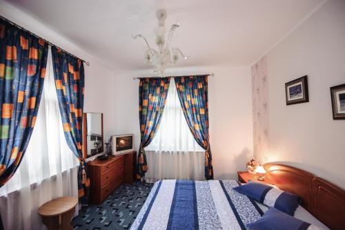 a bedroom with a bed and a window with curtains at Vila Lili in Băile Govora