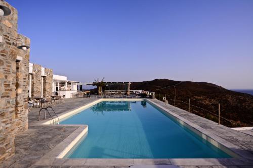 - une piscine d'eau bleue en face d'un bâtiment dans l'établissement Rizes Hotel, à Livadakia