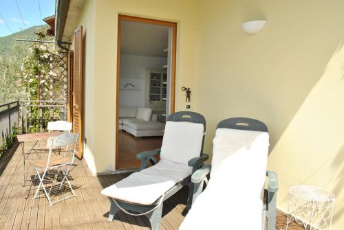 two chairs and a table on a balcony at Residence Fairy Tale in Bellano