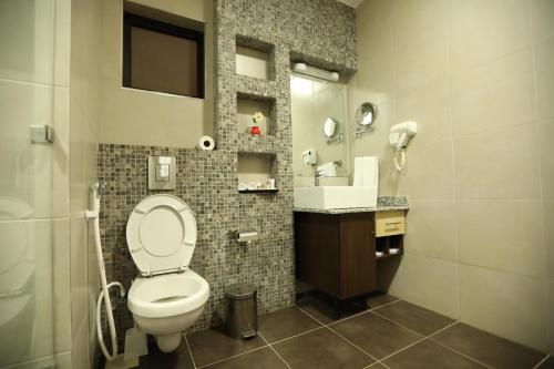 a bathroom with a toilet and a sink at Bidwood Suite Hotel in Nairobi