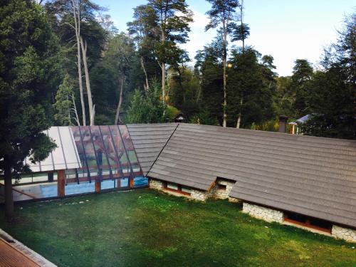a house with a large roof and a yard at Encanto del Rio in Villa La Angostura