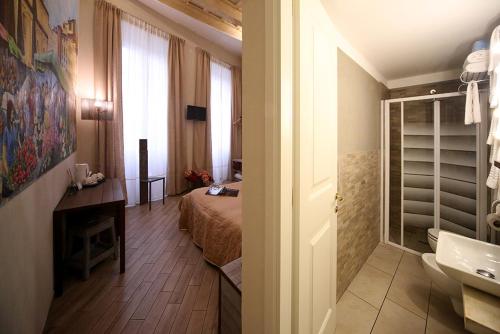 フィレンツェにあるB&B Locanda Il Salimbeccoのベッドルーム1室(ベッド1台付)、バスルーム(シンク付)