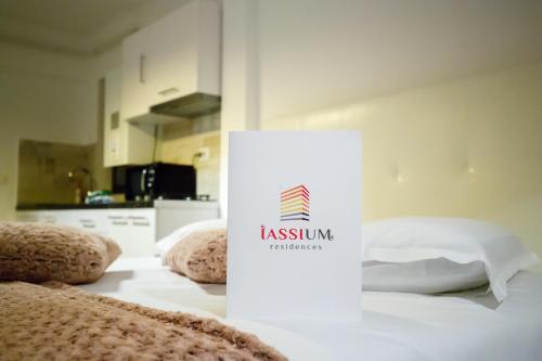 ヤシにあるMetropolitan Iassium Luxury Suitesの部屋のベッドの上に座る看板