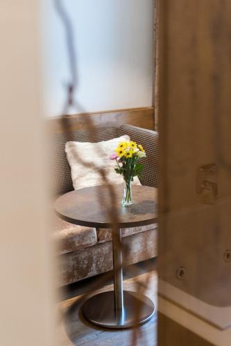 a table with a vase of flowers on it at Weißes Rössl, Mühldorf in der Wachau in Mühldorf