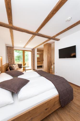 a bedroom with a large bed and a flat screen tv at Weißes Rössl, Mühldorf in der Wachau in Mühldorf