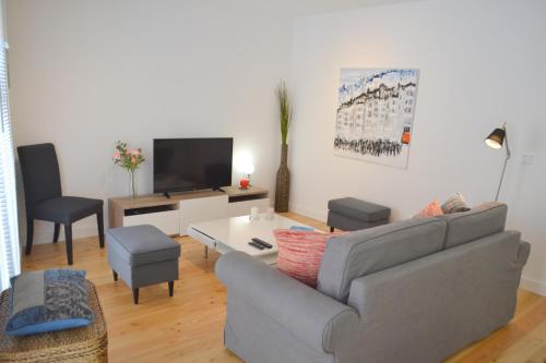 uma sala de estar com um sofá e uma televisão em TP BOMBARDA 5, Lisbon Deluxe Apartment em Lisboa