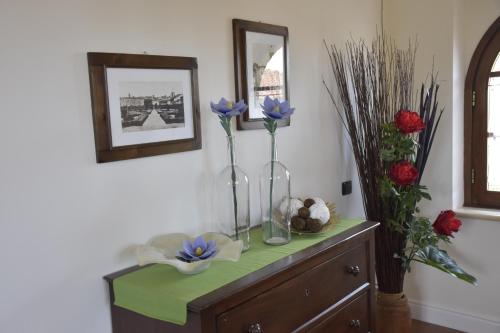 a table with two vases with flowers on it at La Torre House in San Quirico dʼOrcia