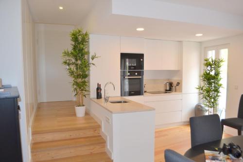 uma cozinha com armários brancos e vasos de plantas em TP BOMBARDA 5, Lisbon Deluxe Apartment em Lisboa