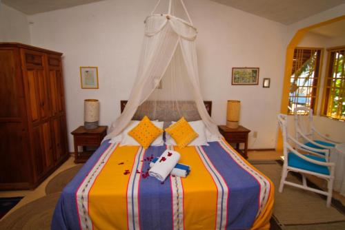 a bedroom with a bed with a canopy at Hotel Gilda in Coyuca