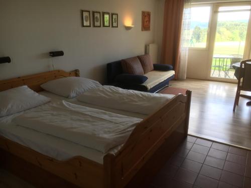 ZandtにあるFerienanlage am Kellerbergのベッドルーム(大型ベッド1台付)、リビングルームが備わります。