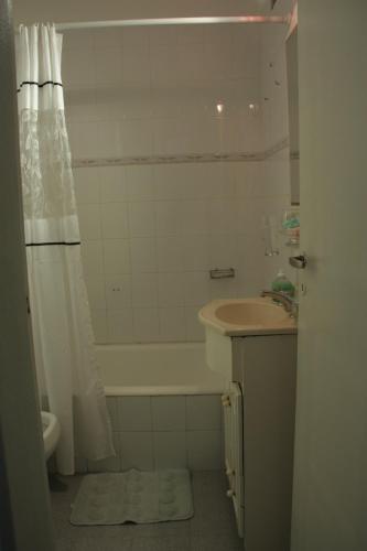 y baño con bañera, lavamanos y ducha. en Departamento Yatay Corrientes en Buenos Aires