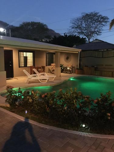 een persoon die voor een huis met een zwembad staat bij Guest House in Playa Flamingo