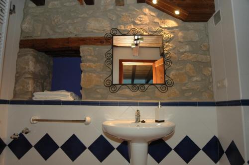 bagno con lavandino e specchio a parete di La Casa del Mercat a Villafranca del Cid