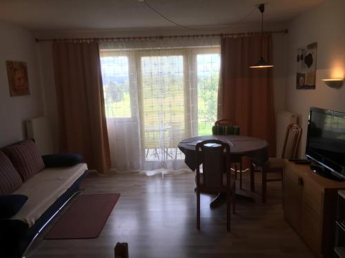 a living room with a table and a couch at Apartmentanlage am Kellerberg in Zandt