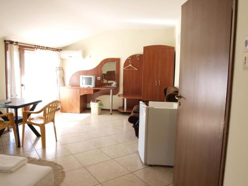 een keuken en een woonkamer met een tafel en een koelkast bij Guestrooms Hema in Sozopol