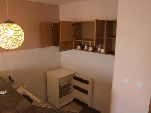 a small kitchen with a small refrigerator and a light at Guestrooms Maria Antoaneta in Sozopol