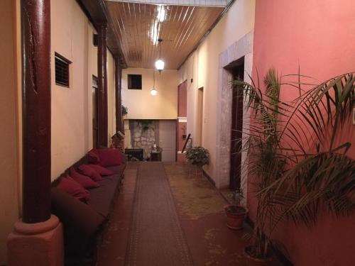 einen Flur mit Sofas und Pflanzen in einem Gebäude in der Unterkunft Hotel Casa Quetzaltenango in Quetzaltenango