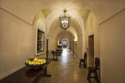 a hallway with a bowl of fruit on a table at Monastero Santa Rosa Hotel & Spa in Conca dei Marini