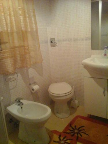 a bathroom with a toilet and a sink at Le Case di Zia Palma in Custonaci