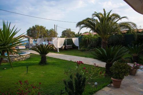 a yard with a hammock and palm trees at Land of Gods in Gythio