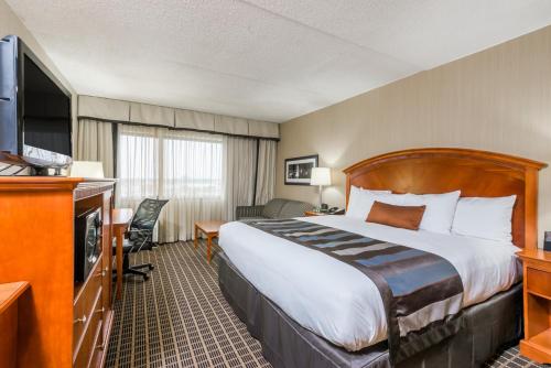 a hotel room with a bed and a television at Wingate by Wyndham Springfield in Springfield