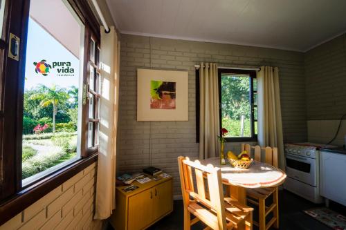a kitchen with a small table and a window at Pura Vida Residence in Morretes