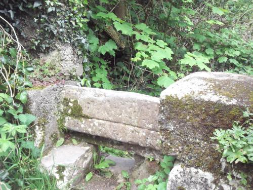 an old stone bench sitting next to a rock at An Stór Townhouse in Midleton